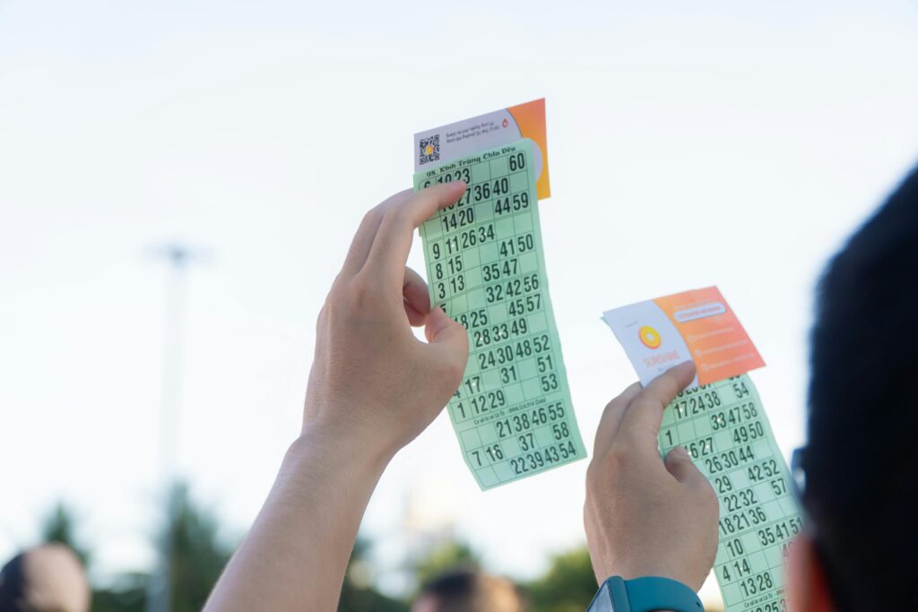Close-up of hands holding transportation tickets, showcasing numbers and fare details.